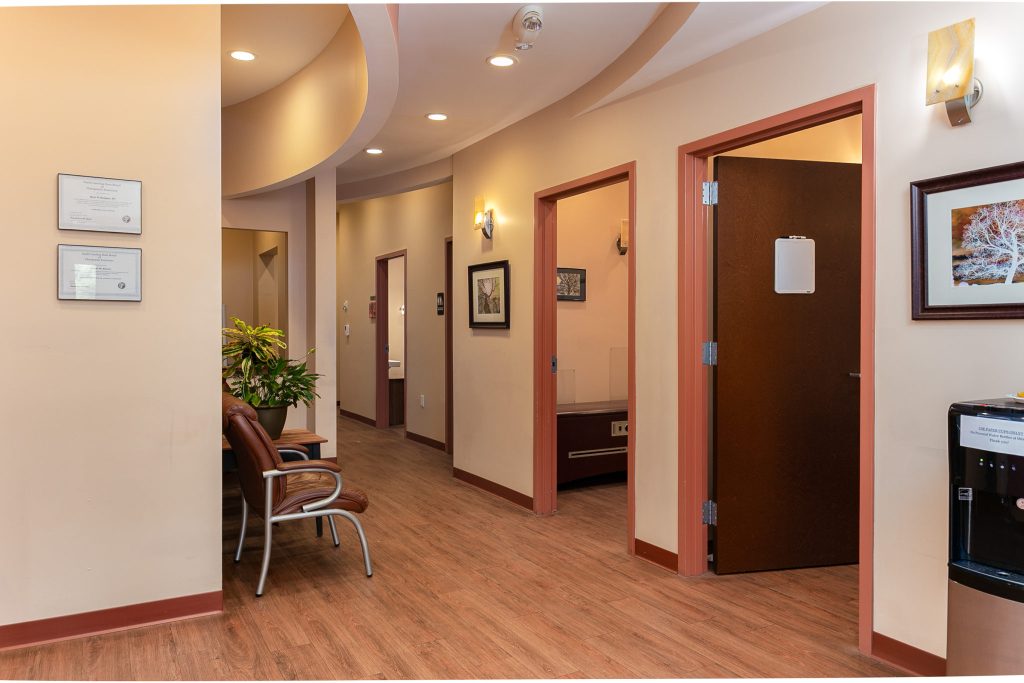 Interior hallway of River Ridge Chiropractic in Asheville, showing professional treatment rooms and framed certifications.